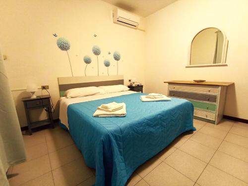 een slaapkamer met een bed met blauwe lakens en bloemen aan de muur bij Appartamento al mare civico28 in Porto Recanati
