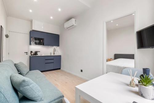 un salon avec un canapé bleu et une cuisine dans l'établissement RIVIERA COZY - Place Massena, à Nice