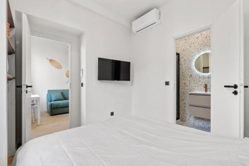 a white bedroom with a bed and a tv at RIVIERA COZY - Place Massena in Nice