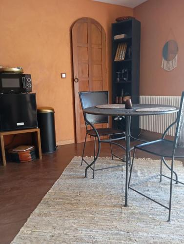 une salle à manger avec une table et deux chaises dans l'établissement la maison bleue, à Ponsas