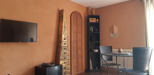 une chambre avec une table, une télévision et une porte dans l'établissement la maison bleue, à Ponsas