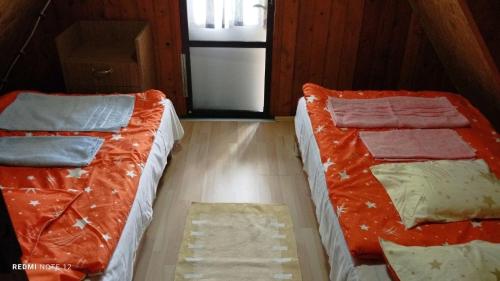 2 Betten nebeneinander in einem Zimmer in der Unterkunft Balatonmáriafürdő Szabó apartman in Balatonmáriafürdő