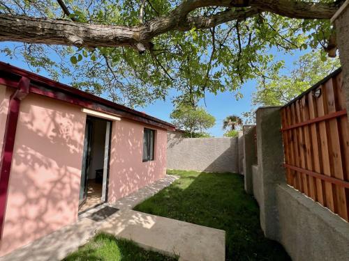 a pink house with a fence and a yard at Pink House in Tsinandali