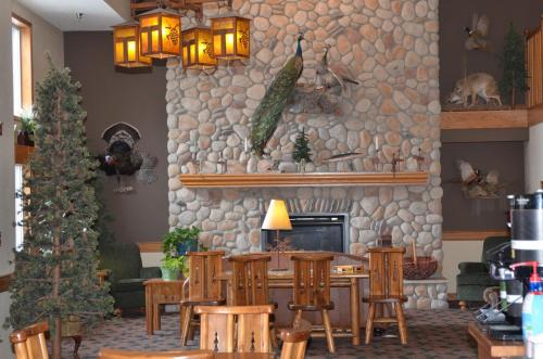 una sala de estar con un árbol de Navidad y una pared de piedra. en Boarders Inn and Suites by Cobblestone Hotels - Fayette, en Fayette