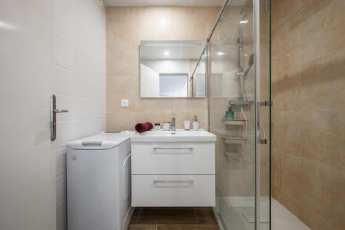 a bathroom with a white sink and a shower at ROCAMARE Piscine toit terrasse - Parking privée - Terrasse in Menton