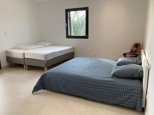 une chambre avec deux lits jumeaux et une fenêtre dans l'établissement Arleya, à Arles