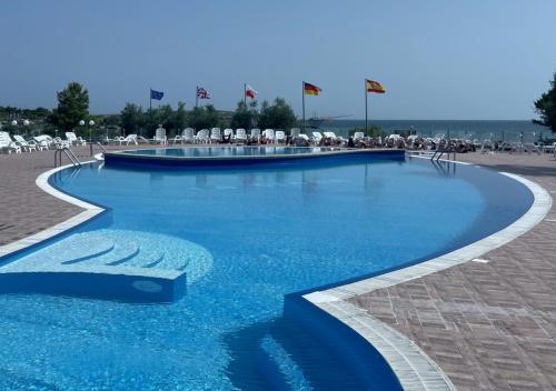 una piscina con agua azul y sillas blancas en Villaggio La Giara, en Vieste