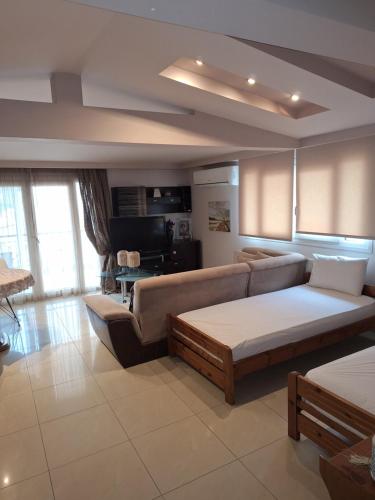 a living room with a couch and a table at revisapartments brown in Neos Marmaras
