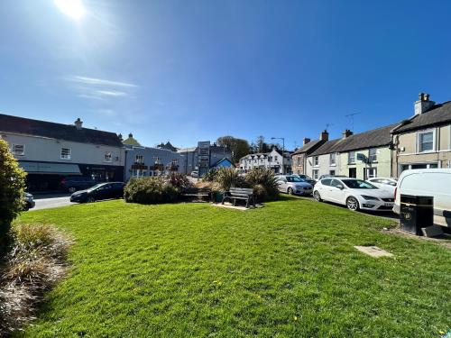 a green yard with cars parked in a parking lot at The Round House in Strangford