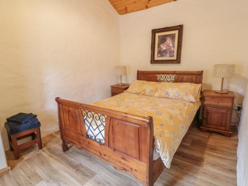 a bedroom with a wooden bed and two night stands at Teach Phaidí Mhóir in Donegal