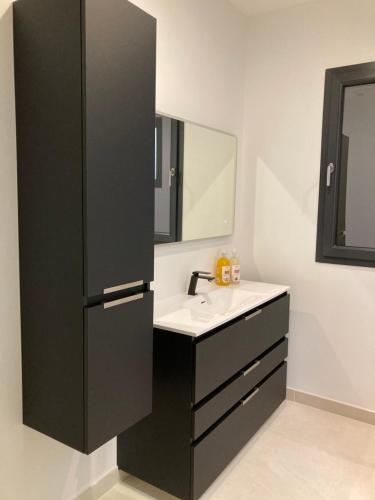 une salle de bain avec un lavabo et un miroir dans l'établissement Arleya, à Arles