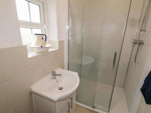 a bathroom with a sink and a glass shower at Teach Phaidí Mhóir in Donegal