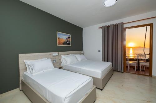 2 letti in una camera con vista sull'oceano di Hotel Idi a Vlorë