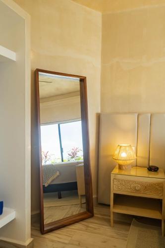 a mirror in a room with a table and a bed at Casa Nawalli Puerto Vallarta Boutique Hotel - Adults Only in Puerto Vallarta