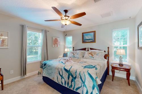 a bedroom with a bed and a ceiling fan at Charming apartment with beautiful marsh views and shared patio in Fernandina Beach