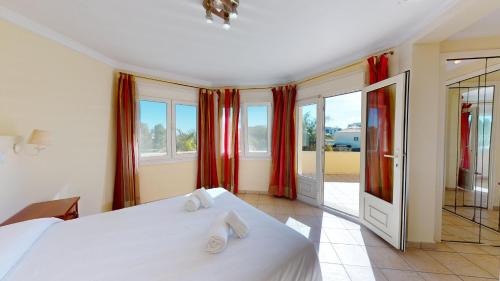 une chambre avec un grand lit blanc et des fenêtres dans l'établissement Greenview Villa by ON Travel, à Oliva