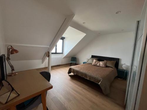 a bedroom with a bed and a desk and a window at En bord de mer, vue et accès direct à la plage in Batz-sur-Mer