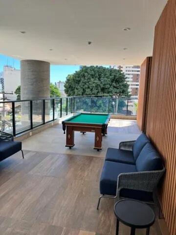 a living room with a pool table on a balcony at Lindo flat em prédio luxuoso - Excelente localização in Goiânia