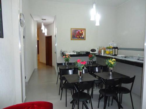 a dining room with tables and chairs with flowers on them at Hotel MM AEROPORTO BRASÍLIA in Núcleo Bandeirante