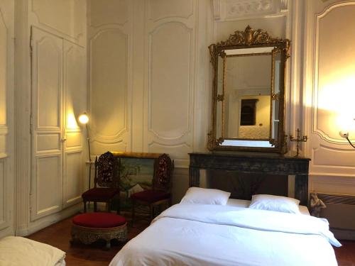 une chambre avec un lit, un miroir et une chaise dans l'établissement T2 devise appartement center ville, à Bordeaux