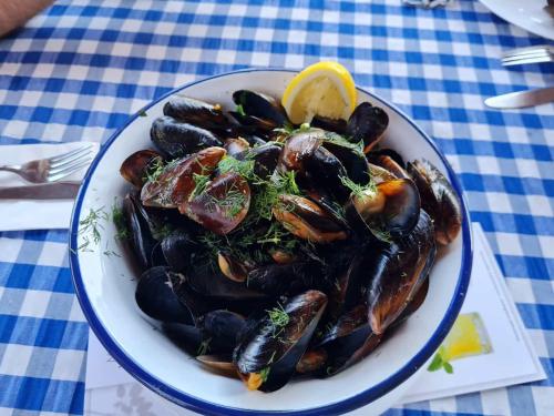 une plaque de moules avec un citron sur une table dans l'établissement DELUXE Beach Apartment in Sveti Vlas, à Sveti Vlas