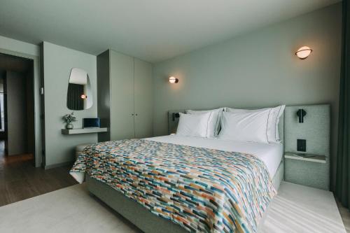 a bedroom with a large bed with a colorful blanket at Hotels 705 Porto Prime Home in Porto