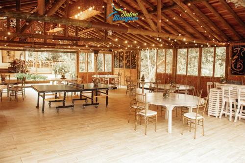 a dining room with tables and chairs and windows at Entrebosques in Santa Elena