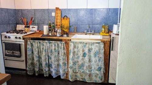 a kitchen with a sink and a stove at Cabaña,Chalet Alpino Bosques de Peralta Ramos in Mar del Plata