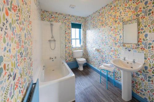 La salle de bains est pourvue d'une baignoire, d'un lavabo et de toilettes. dans l'établissement Sheriffs Tower Cottage - East, à Bishop Auckland