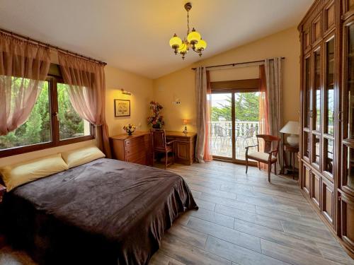 Schlafzimmer mit einem Bett, einem Schreibtisch und Fenstern in der Unterkunft La AMISTAD Apartamento en Chalet con piscina compartida in Calpe