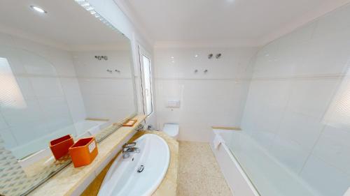 La salle de bains blanche est pourvue d'une baignoire et d'un lavabo. dans l'établissement Nova by Oliva Nova, à Oliva