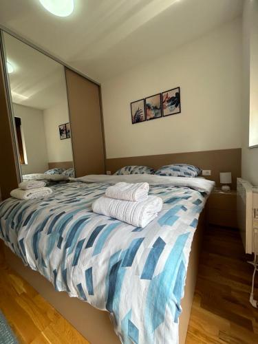 a bedroom with a bed with towels on it at Nirvana 06 in Zlatibor