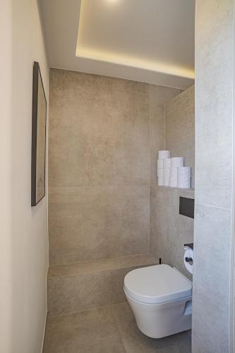 a bathroom with a white toilet and some towels at Villa mit Pool und Garten in Thalheim bei Wels