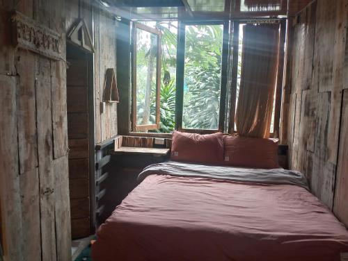 een bed in een kamer met een raam bij DALAT INN DISCOVERY HOSTEL in Da Lat