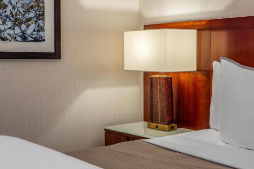 um quarto com uma cama e um candeeiro sobre uma mesa em The Westin Boston Seaport District em Boston