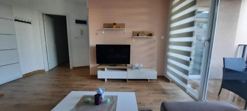 a living room with a television and a white table at Apartman Sara S in Veliko Gradište