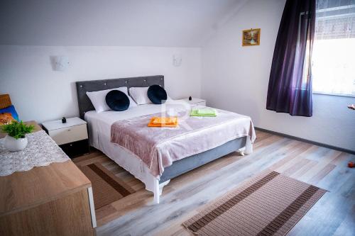 um quarto com uma cama com uma colcha branca e almofadas azuis em Villa Dalmacija em Prijedor