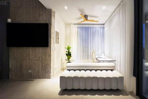a living room with a white ottoman in front of a window at KUNUK- Walk to Hermosa beach in Santa Teresa Beach