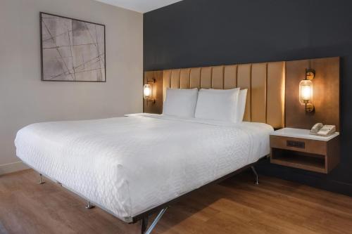 a large bed in a hotel room with a phone at Best Western Plus Meadowlands in Secaucus