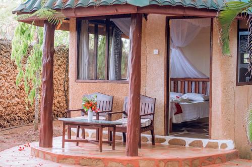 ディアニ・ビーチにあるKijani Cottages - In Dianiのテーブルと椅子、ベッドが備わる家