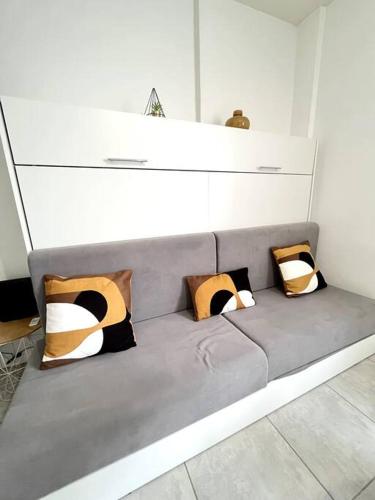 - un canapé avec des oreillers dans l'établissement Studio Lumière du Centre - Parking - Romans, à Romans-sur-Isère