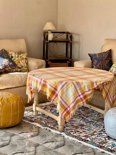 Oulad YoussefLa Casa Blanca • Ecolodge Vert的客厅里有一张桌子和一张沙发