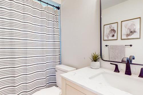 a bathroom with a shower curtain and a sink at Poolside Postcards in Kissimmee