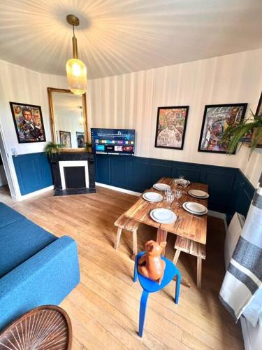 un salon avec une table et un canapé bleu dans l'établissement T3 Le Louvre d' Enghien 2 Rooms 3 Beds 10mn Paris, à Enghien-les-Bains