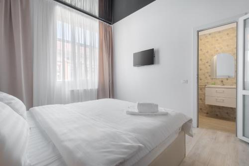 a white bedroom with a large bed and a window at VIVERIA in Oradea