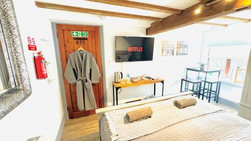 a bedroom with a bed and a table and a television at Swallow Barn in Penrith