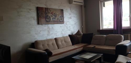 a living room with a couch and a painting on the wall at Apartman Sweet dreams 1 in Niš