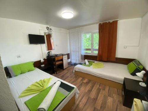 Zimmer mit 2 Betten und einem Schreibtisch mit einem Computer in der Unterkunft Family Hotel Julian in Kranewo