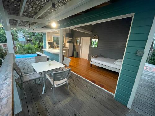 - une terrasse couverte avec une table, des chaises et un lit dans l'établissement Très joli bungalow et sa petite piscine privee, à Rivière-Salée