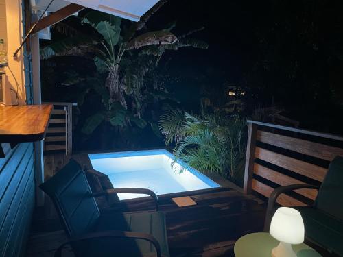 a hot tub sitting on a patio at night at Très joli bungalow et sa petite piscine privee in Rivière-Salée